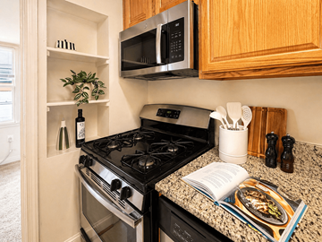 Chevy Chase apartment for rent - A kitchen with a black stove and a black microwave above it.