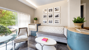 Washington apartment for rent - A living room with a grey couch, a white coffee table, and a glass table with a plant on it.