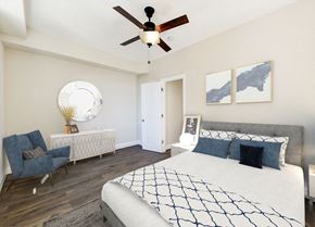 Washington apartment for rent - bedroom with bed, nightstand, dresser, sitting area and ceiling fan at petworth station apartments in washington dc
