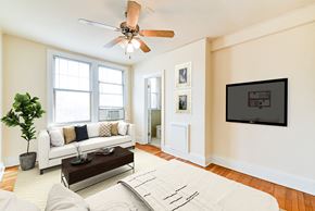 Washington apartment for rent - studio apartment showing sofa, bed, ceiling fan, large windows and view of kitchen at the foreland apartments in washinton dc