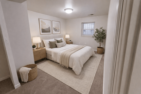 Washington apartment for rent - A bedroom with a large bed, two lamps, and a plant.