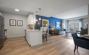 Newton apartment for rent - A kitchen with a white island and a dining table with chairs.