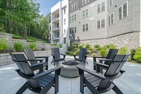 Winchester apartment for rent - A patio with black chairs and a fire pit in front of a building.