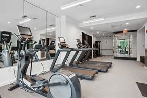 Winchester apartment for rent - A spacious gym with treadmills, elliptical machines, and a mirrored wall.