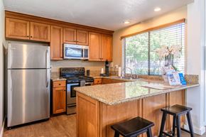 Costa Mesa apartment for rent - A kitchen with wooden cabinets and a granite countertop.