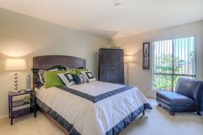 Costa Mesa apartment for rent - A bedroom with a large bed and a blue chair.