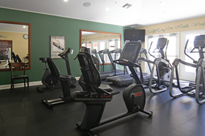 Placentia apartment for rent - A gym with a green wall and a row of treadmills.