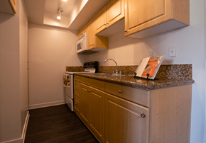 Fullerton apartment for rent - A kitchen with wooden cabinets and a granite countertop.