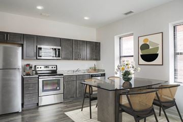 Baltimore apartment for rent - A modern kitchen with a stainless steel refrigerator and a glass island.