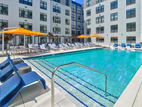Owings Mills apartment for rent - A swimming pool with outdoor seating at The Apartments at Metro Centre
