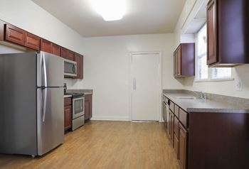A kitchen with wood floors and brown cabinets