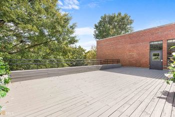 A wooden deck in front of a brick building