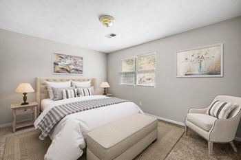 A bedroom with a bed and a chair