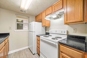 A kitchen with white appliances and wooden cabinets