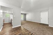 Norcross apartment for rent - A spacious room with wooden floors and white walls.