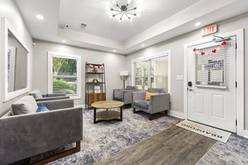 A living room with a grey couch, a wooden coffee table, and a white door.
