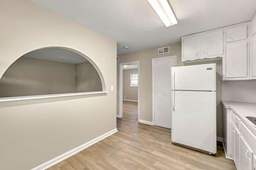 Lilburn apartment for rent - A kitchen with a white refrigerator and wooden floors.