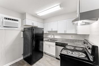 A kitchen with white cabinets and black appliances