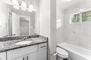 A bathroom with a sink toilet and bathtub
