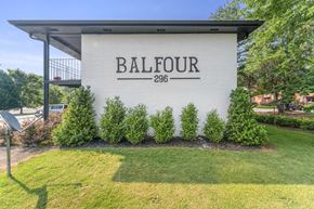 Lilburn apartment for rent - a building with a lawn and trees in front of it  at Balfour 296, Lilburn, Georgia