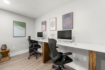 A home office with two desks and two computer monitors