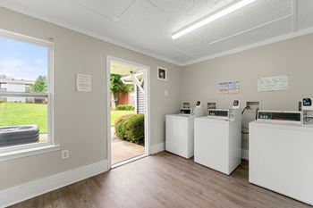A laundry room with two washing machines and a door to a yard