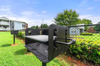 A bench in a park next to a chain link fence