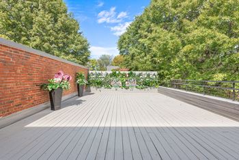 A deck with a brick wall and a wooden floor
