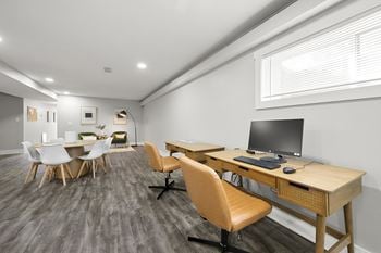A room with desks and chairs and a computer