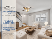 Sandy Springs apartment for rent - A room with a staircase and a couch with a sign offering a free month of rent.