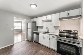 Atlanta apartment for rent - a kitchen with stainless steel appliances and white cabinets at Gardens at Washington Park, Atlanta, Georgia