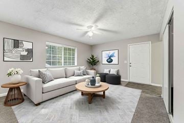 Decatur apartment for rent - A living room with a grey couch, a coffee table, and a painting on the wall.
