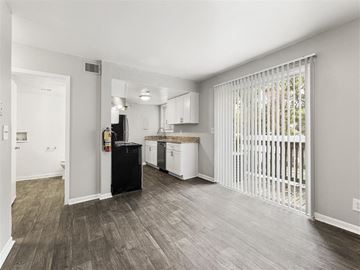 Tucker apartment for rent - A kitchen with white cabinets and a black fridge.