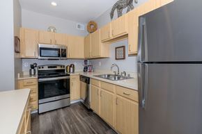 Arvada apartment for rent - A kitchen with wooden cabinets and stainless steel appliances.