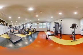 Longmont apartment for rent - a gym with cardio equipment and a yellow circle on the floor
