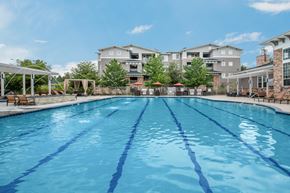 Arvada apartment for rent - A large swimming pool in front of apartment buildings.