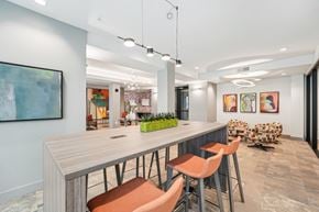 Tampa apartment for rent - A modern dining room with a long table and orange chairs.