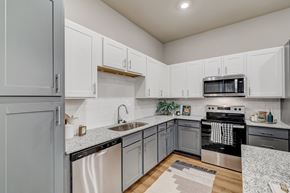 Georgetown apartment for rent - A kitchen with white cabinets and a black stove top oven.