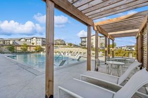 Georgetown apartment for rent - A pool area with sun loungers and a wooden pergola.