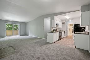 Vancouver apartment for rent - A spacious, empty room with a kitchenette and a window.