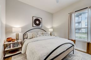 Georgetown apartment for rent - A bedroom with a large bed and a wreath on the wall.