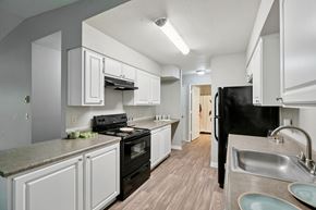 Vancouver apartment for rent - A kitchen with black appliances and white cabinets.