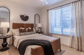 Kansas City apartment for rent - A bedroom with a large bed and a window with curtains.