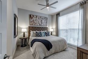 Chattanooga apartment for rent - A bedroom with a large bed and a ceiling fan.