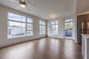 Portland apartment for rent - A spacious room with a ceiling fan and large windows.