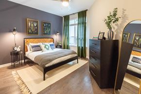 Decatur apartment for rent - A bedroom with a bed, nightstand, and a dresser with a mirror.