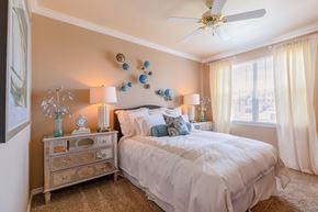 Colorado Springs apartment for rent - a bedroom with a bed and a dresser and a ceiling fan