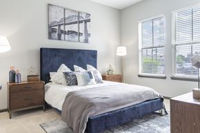 Chattanooga apartment for rent - A bedroom with a large bed and a bridge picture on the wall.