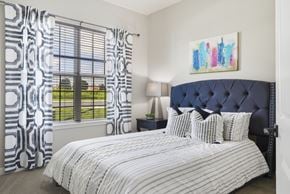 Overland Park apartment for rent - A bedroom with a large bed and a painting on the wall.