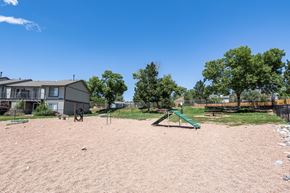 Colorado Springs apartment for rent - a playground with a swing set and a house in the background